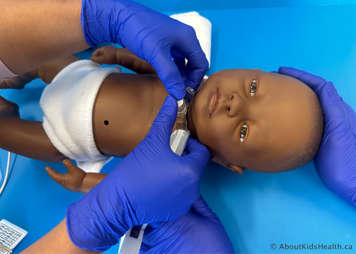 Supporting a child while a tracheostomy tube is inserted into their tracheostomy stoma