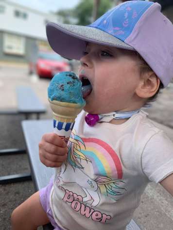 Child with a tracheostomy tube eating ice cream