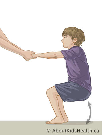 Child squatting with someone supporting them by the hands