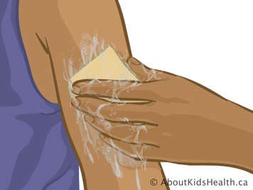 Cleaning upper arm with sponge and soapy water