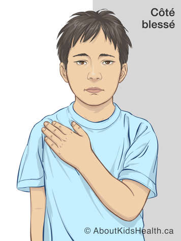 Enfant tenant la main de son bras blessé à l'épaule du côté opposé