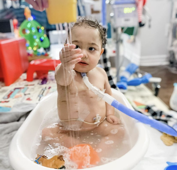 Child with a tracheostomy tube in a bath