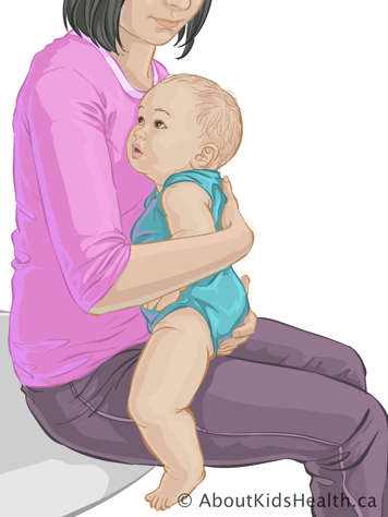 Mother holding baby sitting up on her lap, facing toward her chest