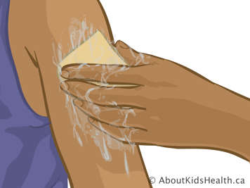 Cleaning upper arm with sponge and soapy water
