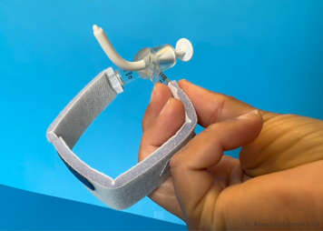 Inspecting a tracheostomy tube to make sure it is not bent or cracked or discoloured