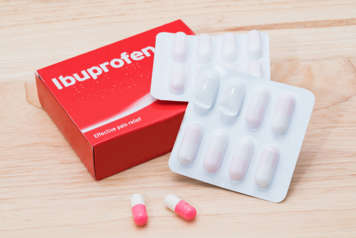 Tablets of ibuprofen next to packets