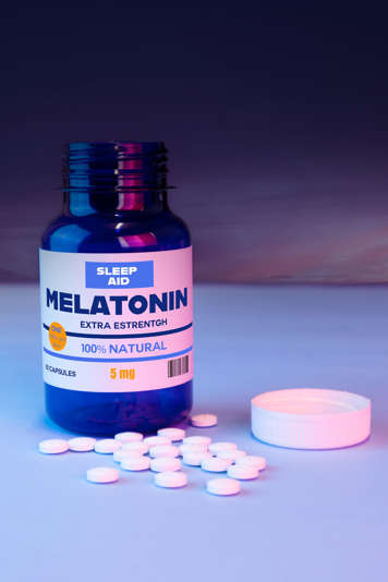 Melatonin tablets next to bottle of melatonin