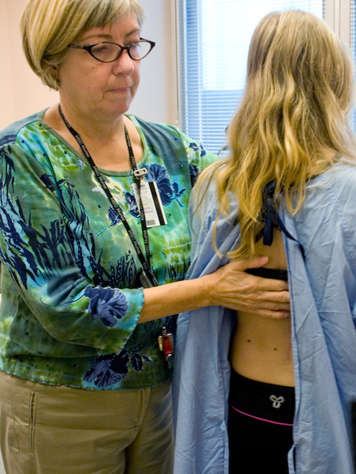Infirmière qui examine le dos d'un patient