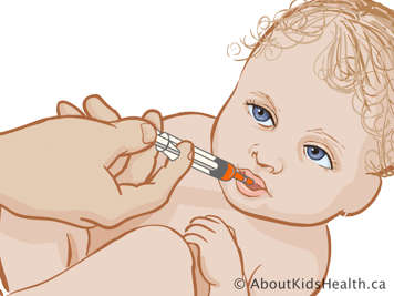 Bebé a receber medicamento por via oral com uso de seringa