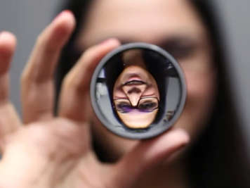 An optometrist holds up a lens