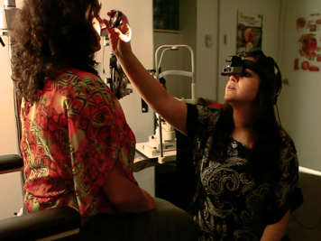 An optometrist wearing special glasses for an examination