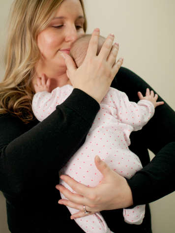 Tenant bébé à la poitrine en pliant et dépliant les genoux pour faire faire un rot au bébé