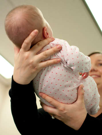 Étendant les mains pour soutenir le corps du bébé