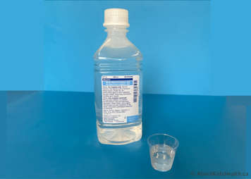 Sterile water in bottle with cup