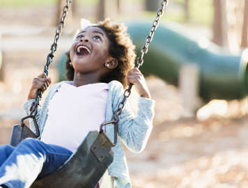 Girl laughing on swing